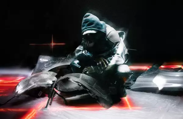 A person wearing all black with their hood up. They are crouching on the floor surrounded by fragments of a broken vehicle.