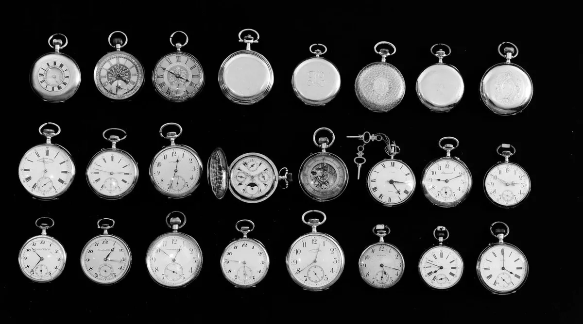 Various vintage pocket watches laid out on a table