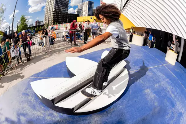 A skater outside Aviva Studios skating over an Adidas logo