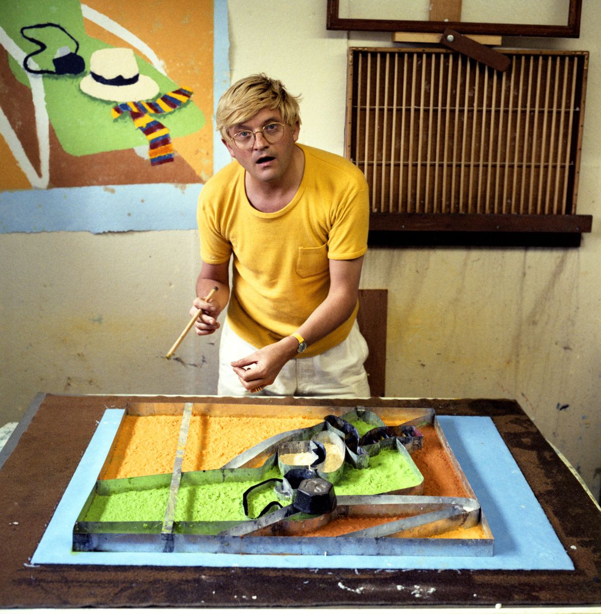 David Hockney pressing colour pulp into a mould for experimental paper pulp work (never published and destroyed) during the 'Paper Pools' series, Tyler Workshop Ltd. paper mill, Bedford Village, New York, 1978.