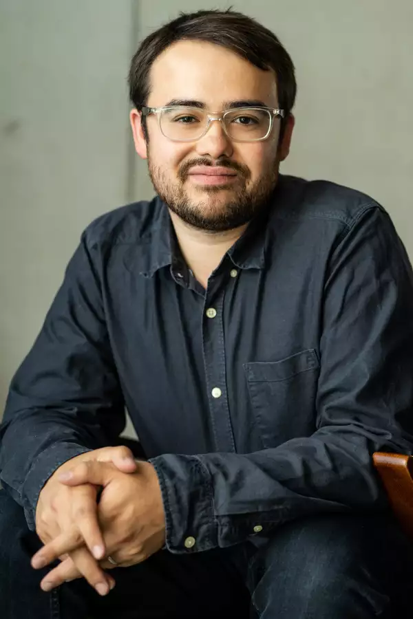 Jordan Li-Smith wearing clear rimmed glasses and a grey shirt