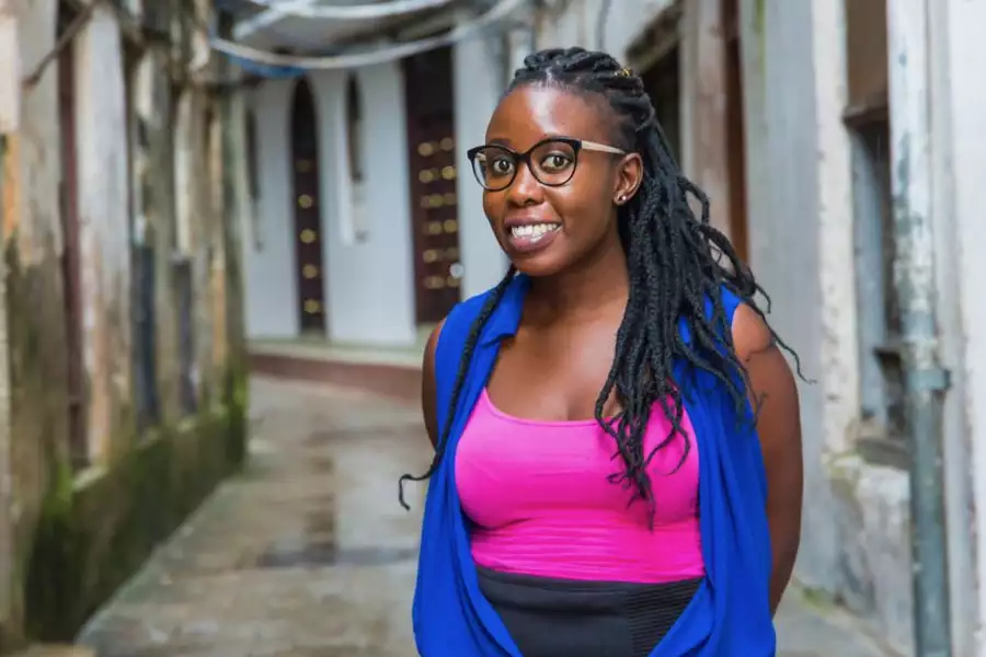 Gift Sally Akinyi O smiling wearing a bright blue and pink top