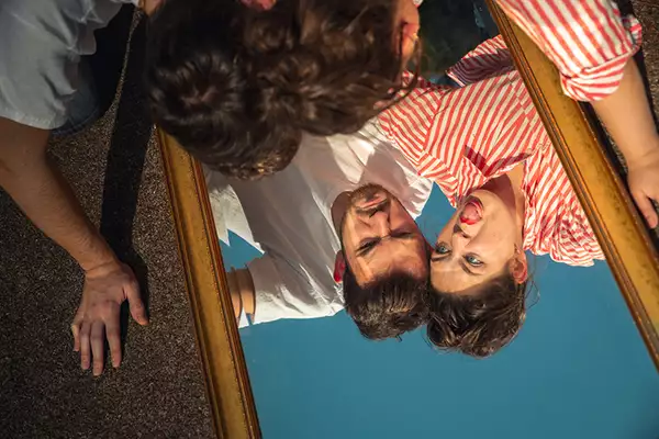 two people who looking into a mirrow upside down pulling fiunny faces