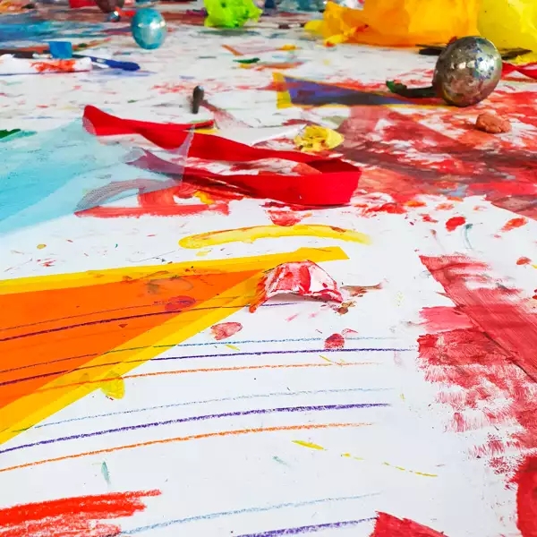 A white sheet of paper with abstract and colourful crayon and paint marks