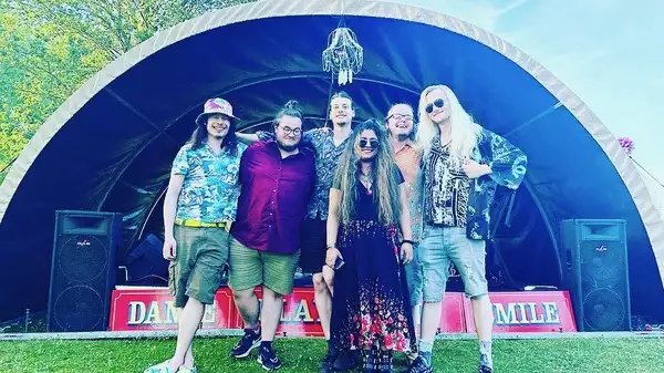 Photo of the band Wingspread stood in front of a stage