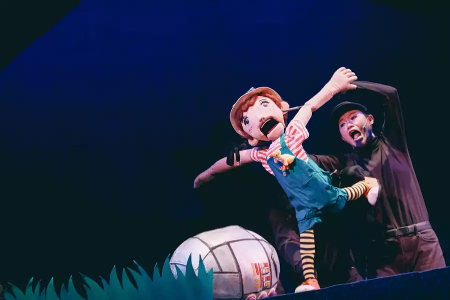 Photo of Pui-ka Cheng on stage with a puppet