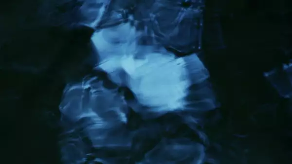 This image has an abstract, fluid-like pattern with deep blue and black tones, creating a sense of flowing water or rippling textures.