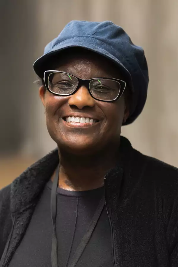 Portrait photograph of Cheryl Struckman wearing a blue cap and black outfit
