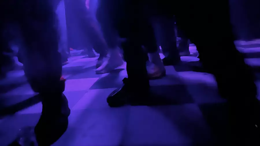 Checkered dancefloor lit up with purple lights